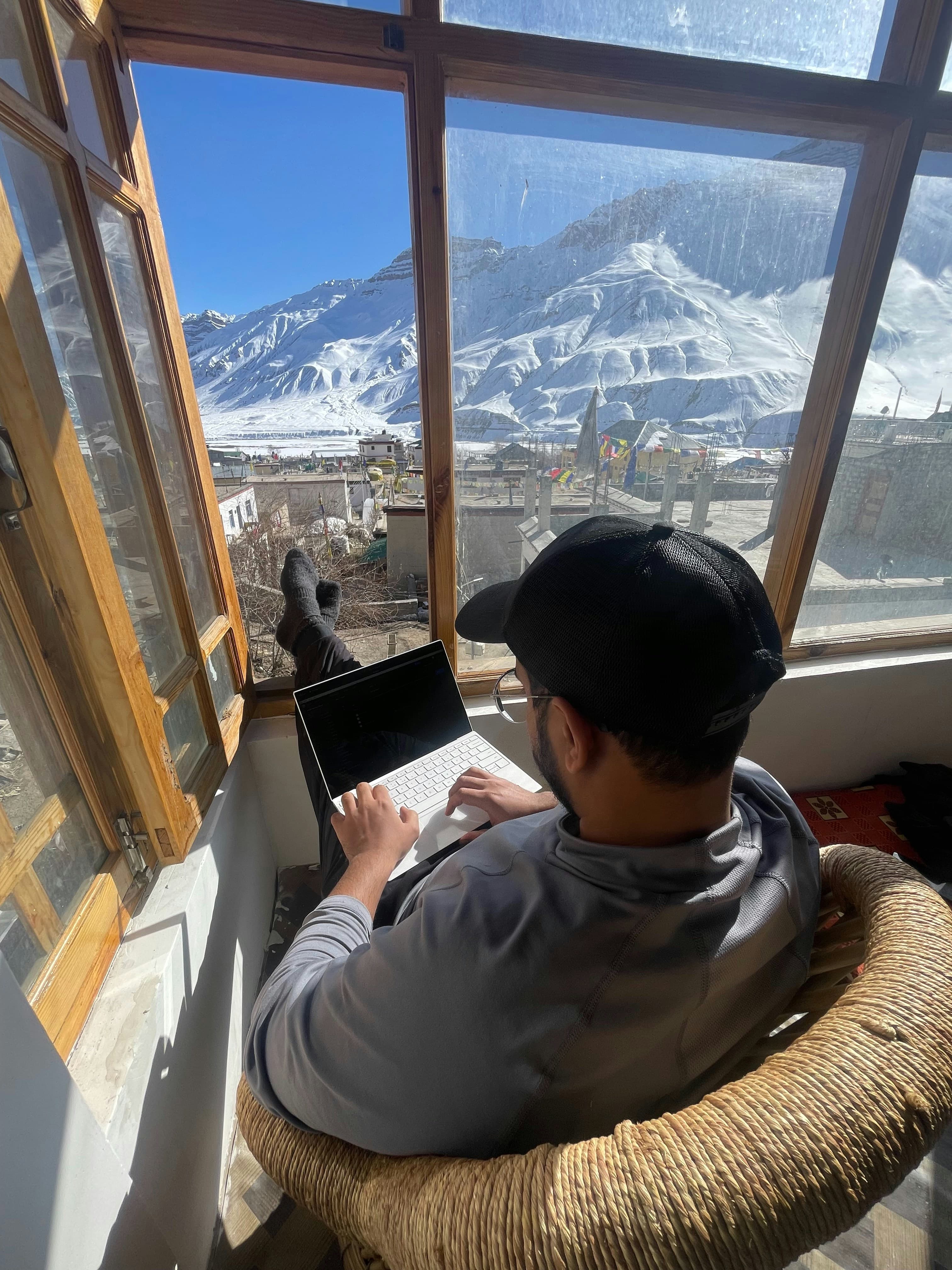 Person working on a laptop with mountain view